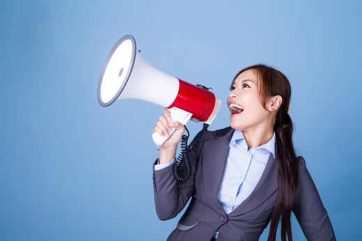 Businesswoman making announcement with megaphone